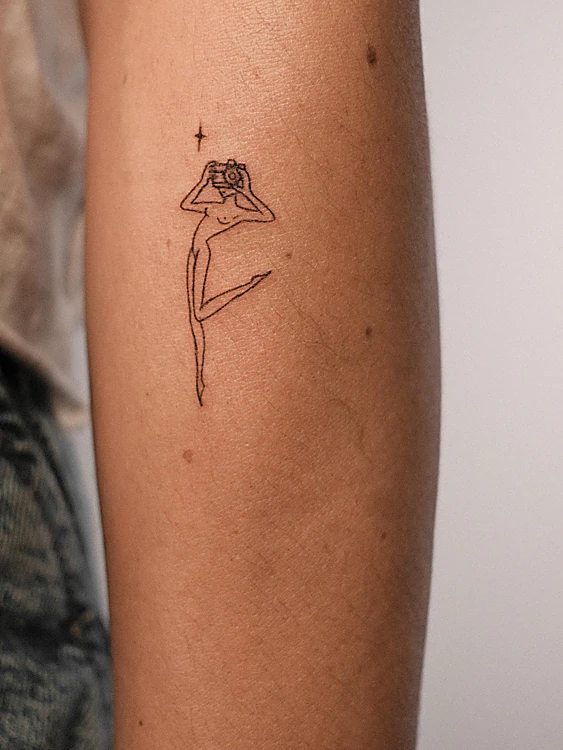 Micro tatuaje de línea fina: una bailarina con una estrella en el antebrazo