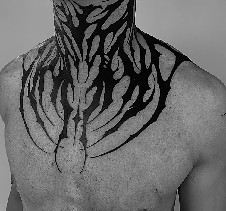 Blackwork ornamental de trazos negros que baja del cuello al pecho