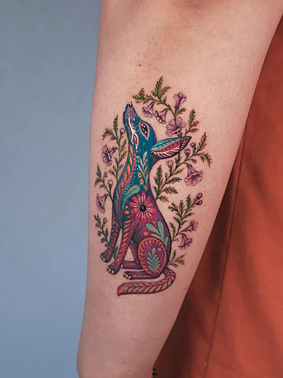 Liebre ilustrativa a color rodeada de flores en el antebrazo