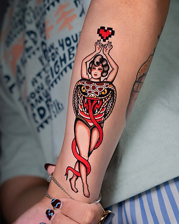 Tatuaje tradicional a color: mujer abrazada por una serpiente roja en el antebrazo
